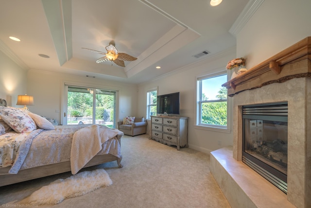 carpeted bedroom with a raised ceiling, ceiling fan, and ornamental molding