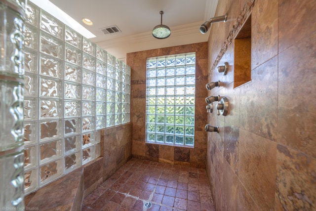 bathroom featuring a wealth of natural light, crown molding, tile walls, and walk in shower