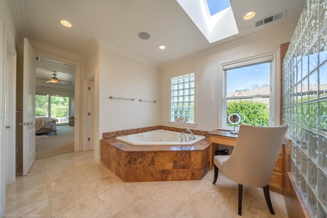 bathroom with tiled tub, ceiling fan, crown molding, and a healthy amount of sunlight