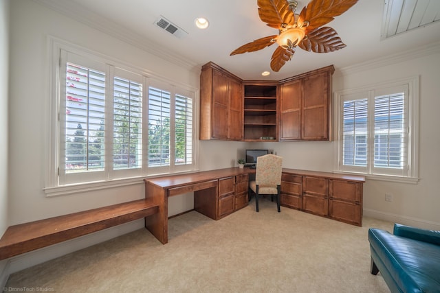 carpeted home office featuring ceiling fan, built in desk, and ornamental molding