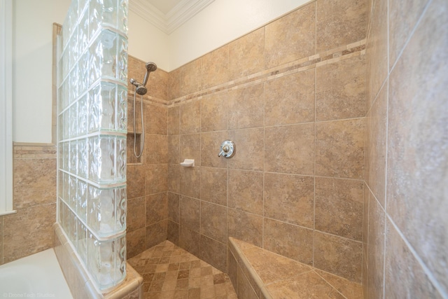 bathroom featuring a tile shower and crown molding