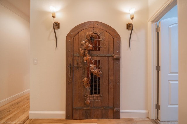 hall featuring wood-type flooring and ornamental molding