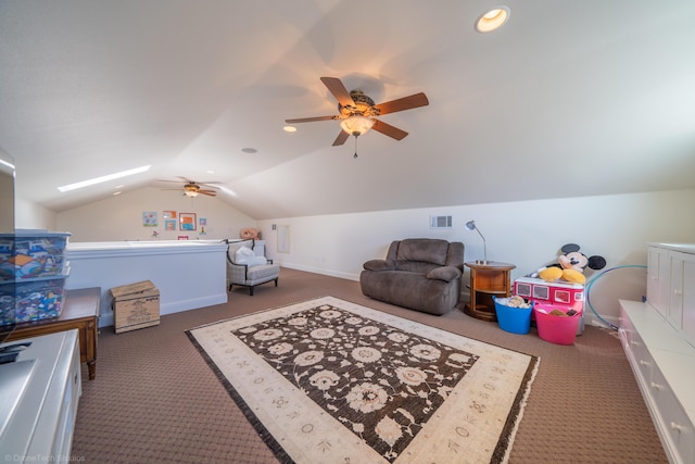 recreation room with dark colored carpet, lofted ceiling with skylight, and ceiling fan