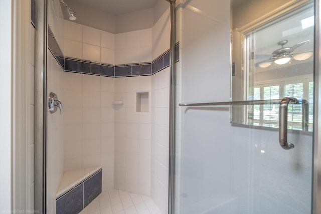 bathroom featuring ceiling fan and a shower with door