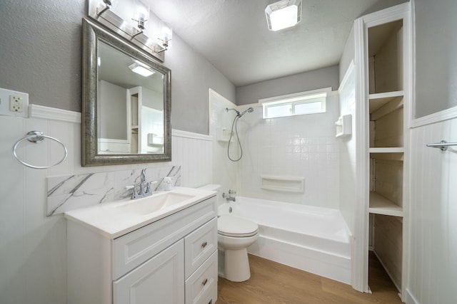 full bathroom with vanity, hardwood / wood-style flooring, toilet, and tiled shower / bath