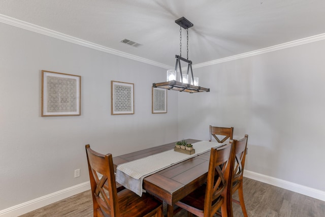 dining room featuring ornamental molding and hardwood / wood-style flooring