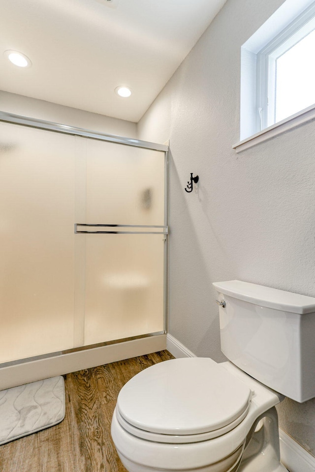 bathroom featuring wood-type flooring, toilet, and walk in shower