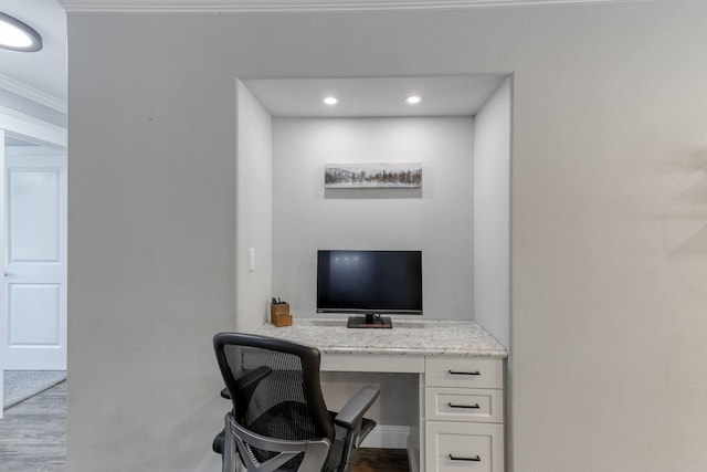 office with built in desk, light wood-type flooring, and crown molding