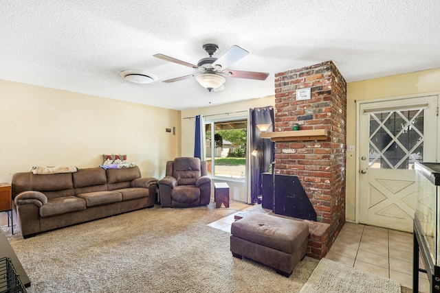 living room with ceiling fan, light tile patterned floors, and a textured ceiling