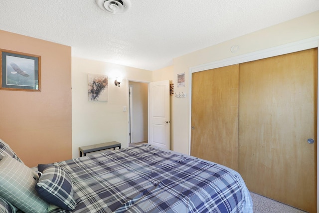 bedroom with carpet, a textured ceiling, and a closet