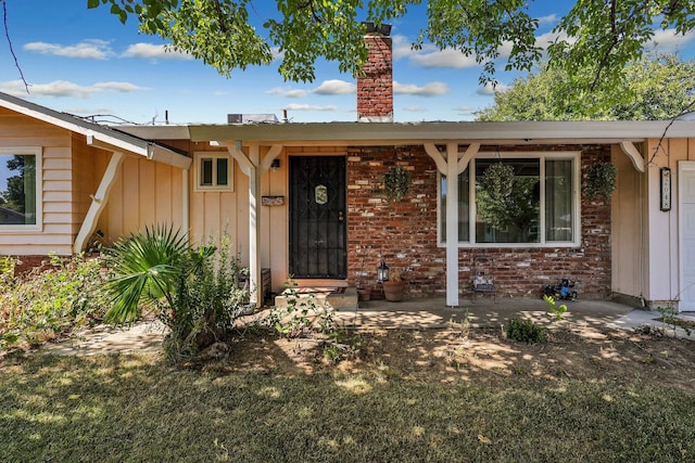 doorway to property featuring a lawn