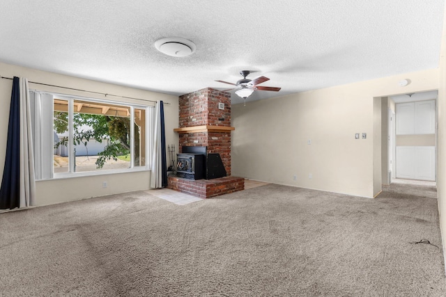 2048 Wilder Dr, Redding, CA 96001 - unfurnished living room featuring carpet flooring, ceiling fan, a textured ceiling, and a wood stove
