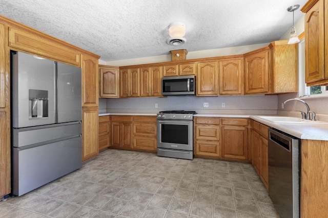 2048 Wilder Dr, Redding, CA 96001 - kitchen featuring appliances with stainless steel finishes, light countertops, brown cabinets, decorative light fixtures, and a textured ceiling