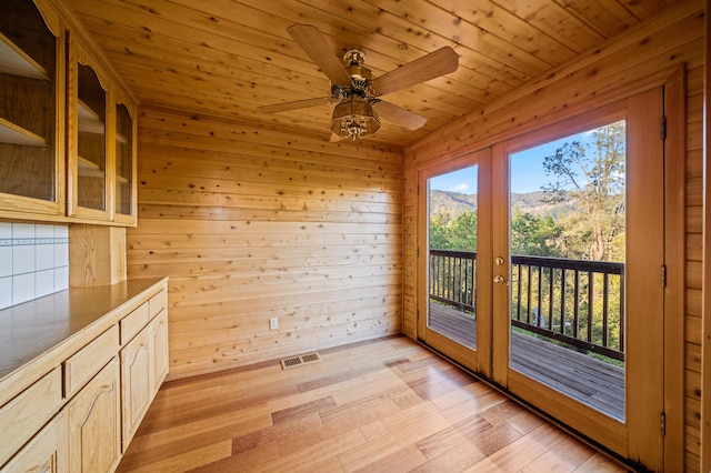 interior space featuring a mountain view, french doors, wood walls, and wood ceiling