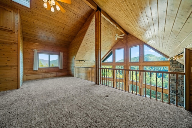 additional living space with wood ceiling, ceiling fan, high vaulted ceiling, beamed ceiling, and wood walls