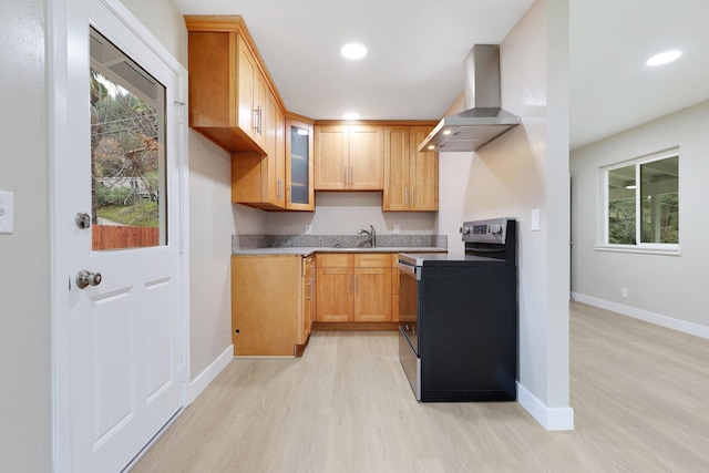 kitchen with light hardwood / wood-style flooring, a wealth of natural light, stainless steel range with electric cooktop, and wall chimney range hood