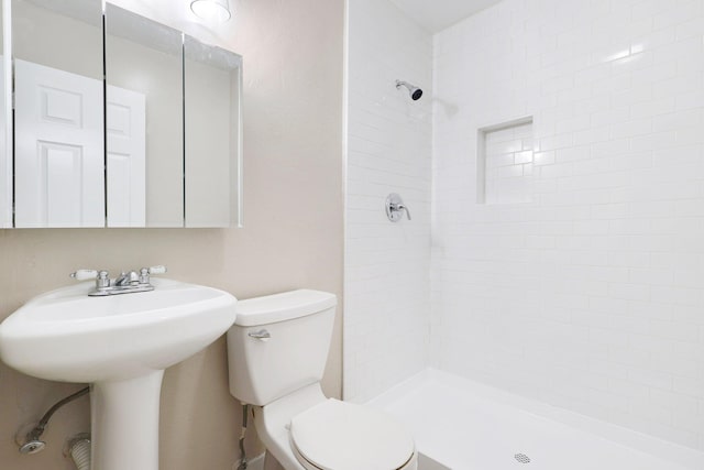 bathroom with tiled shower and toilet