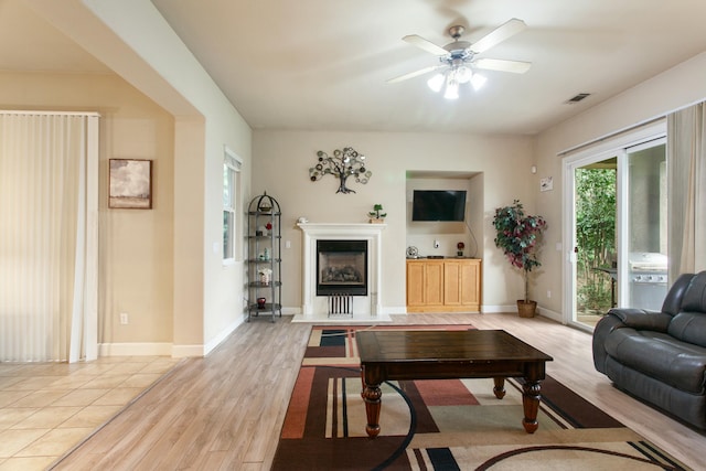 living room with light wood-type flooring and ceiling fan