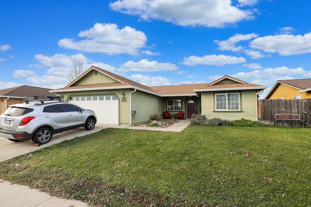 single story home featuring a garage and a front lawn