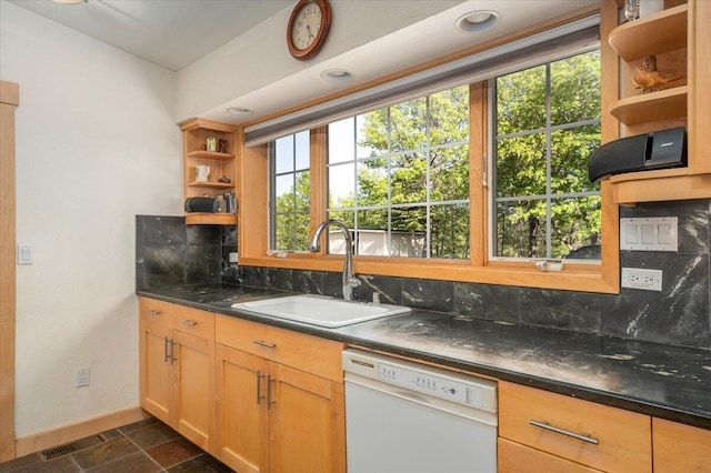 kitchen with decorative backsplash, sink, white dishwasher, and light brown cabinets