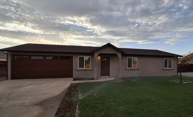 ranch-style house with a garage and a yard