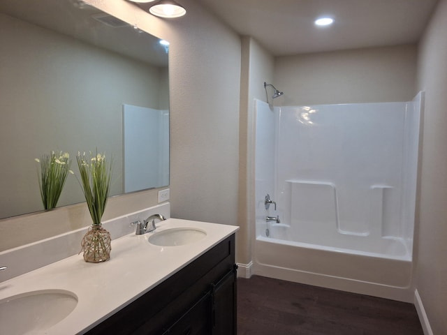 bathroom featuring hardwood / wood-style floors, vanity, and bathing tub / shower combination