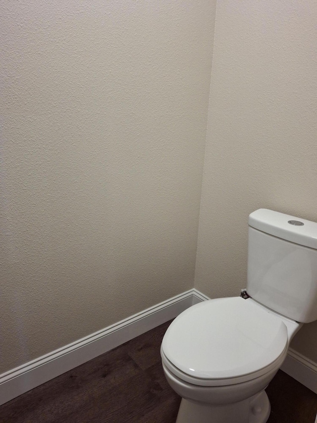 bathroom featuring toilet and wood-type flooring