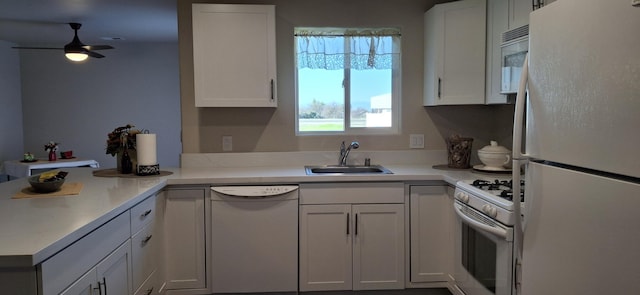 kitchen featuring white appliances, white cabinets, sink, kitchen peninsula, and ceiling fan