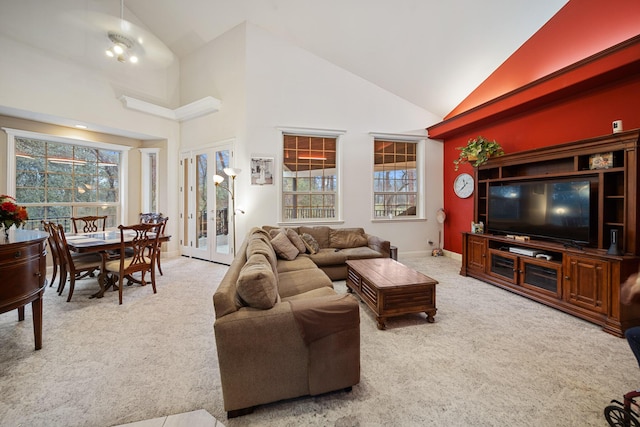 carpeted living room featuring plenty of natural light, high vaulted ceiling, and french doors