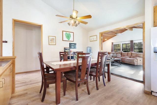 dining area with light wood-type flooring and lofted ceiling