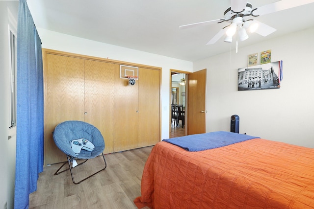 bedroom featuring ceiling fan, light wood-type flooring, and a closet