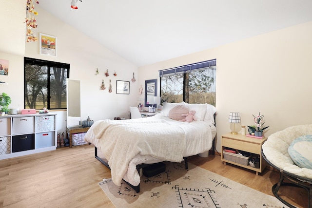 bedroom featuring light hardwood / wood-style flooring and high vaulted ceiling