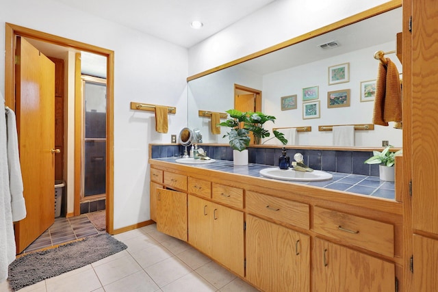 bathroom featuring tile patterned flooring, walk in shower, and vanity