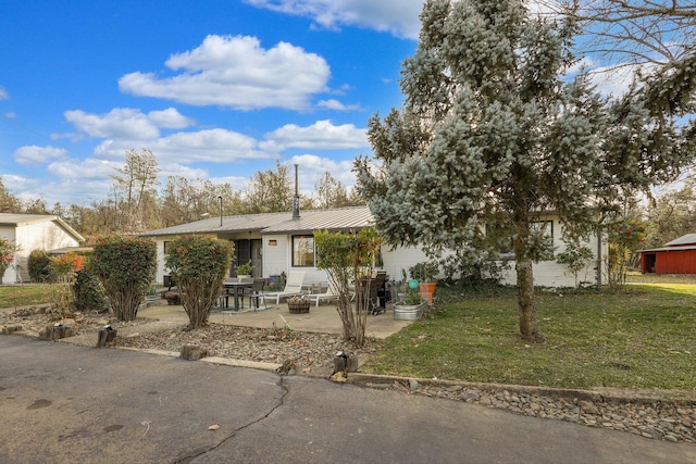 view of front of house featuring a front yard and a patio