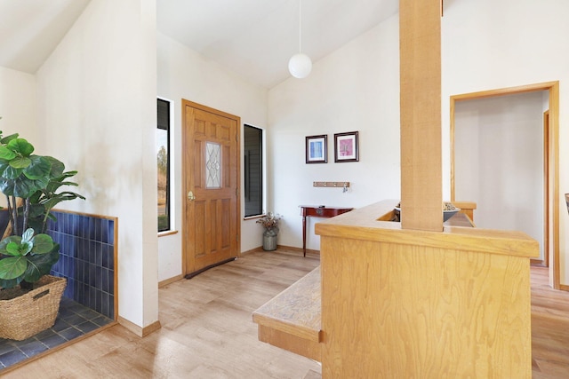 entryway with high vaulted ceiling and wood-type flooring