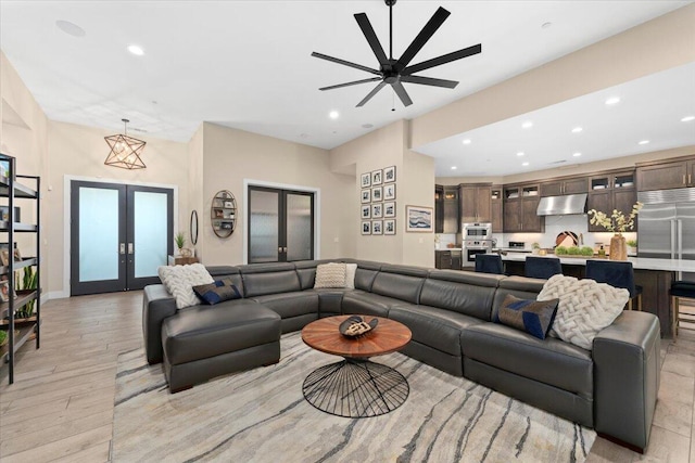 living room with ceiling fan, light hardwood / wood-style floors, and french doors