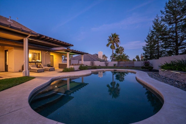 pool at dusk featuring a patio