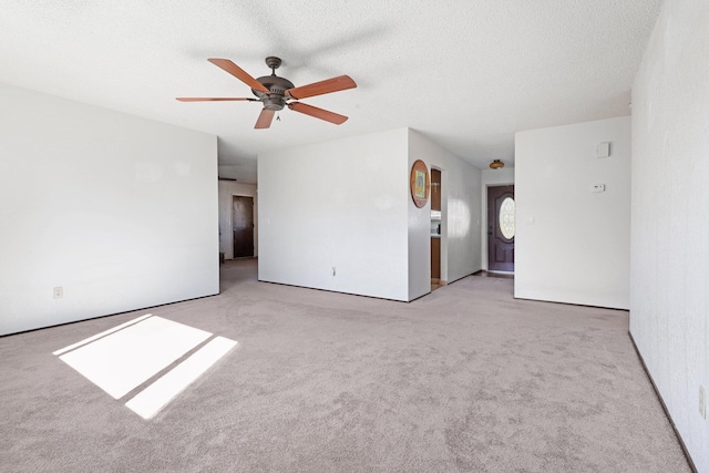 carpeted spare room with ceiling fan and a textured ceiling