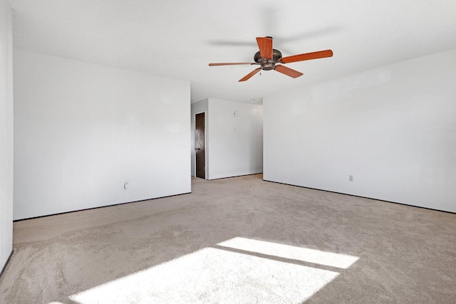 carpeted spare room featuring ceiling fan