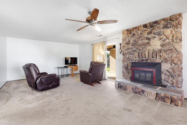 living room featuring a fireplace, carpet floors, a textured ceiling, and ceiling fan