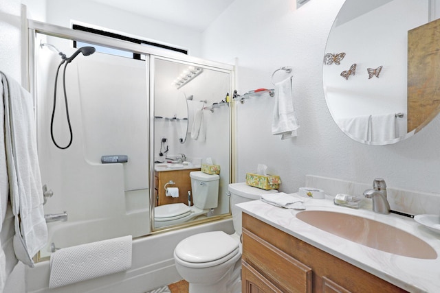 full bathroom featuring vanity, bath / shower combo with glass door, and toilet