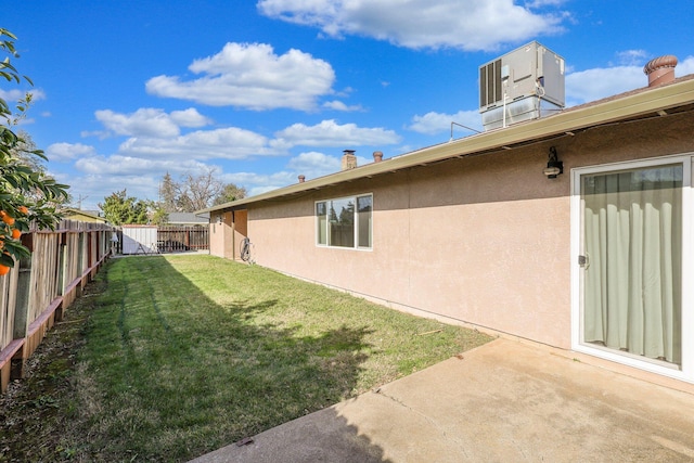 view of yard with central AC unit and a patio