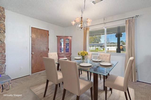 dining room featuring light carpet and an inviting chandelier