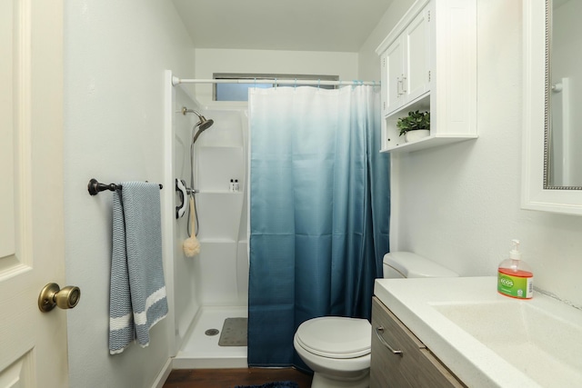 bathroom with toilet, walk in shower, and vanity