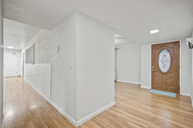 entryway featuring light hardwood / wood-style floors and a textured ceiling