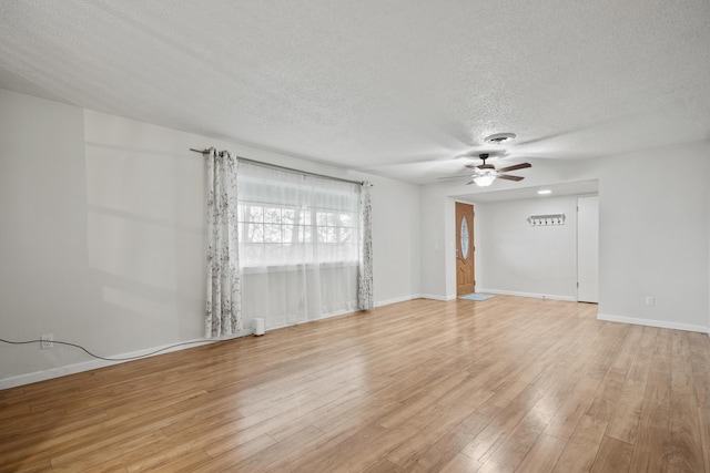 empty room with a textured ceiling, ceiling fan, and light hardwood / wood-style floors