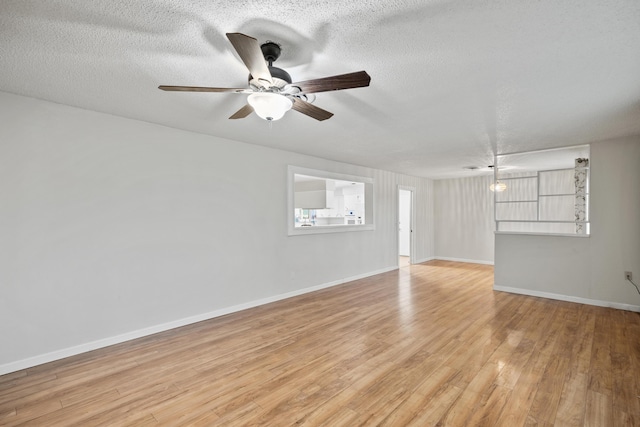 spare room with a textured ceiling, ceiling fan, and light hardwood / wood-style flooring