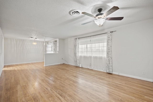 spare room featuring a textured ceiling, ceiling fan, and light hardwood / wood-style floors