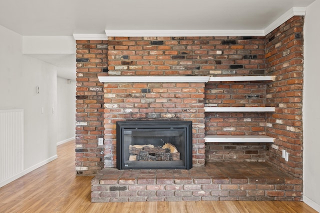 details with a brick fireplace, hardwood / wood-style floors, and crown molding