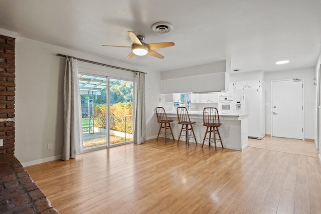 living room featuring ceiling fan and light hardwood / wood-style flooring